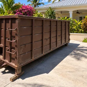 Island Sanitation Plus roll-off dumpster bin placed on a tropical residential driveway