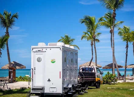 Island Sanitation Plus AC restroom trailer and truck set up on the beach at a resort